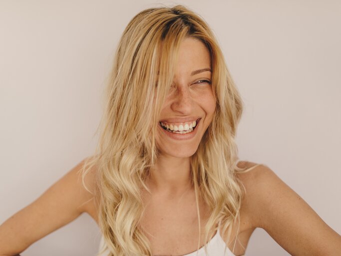 Ungeschminkte blonde Frau lächelt | © Getty Images/AleksandarNakic