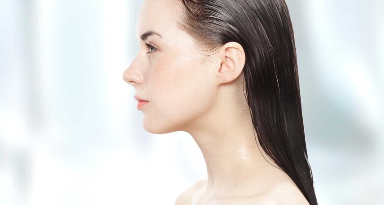 Junge Frau mit nassen Haaren im Seitenprofil. | © Getty Images/Paper Boat Creative