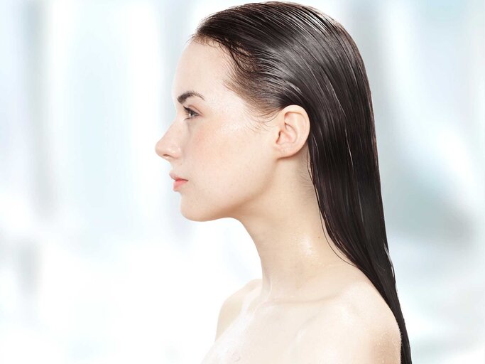 Junge Frau mit nassen Haaren im Seitenprofil. | © Getty Images/Paper Boat Creative