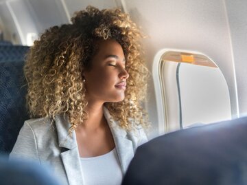 Schöne Frau sitzt im Flugzeug | © Getty Images/SDI Productions