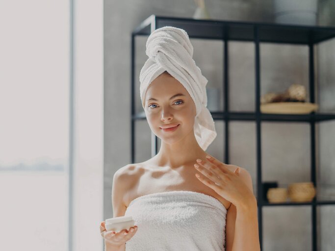 Frau mit Handtuch-Turban steht im Badezimmer | © Getty Images/Viorel Kurnosov / EyeEm