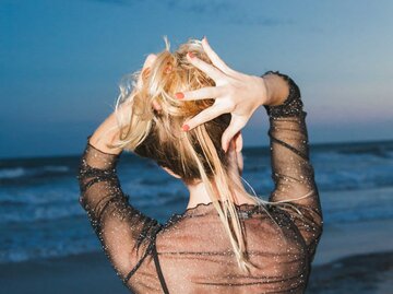 Frau mit hochgesteckten Haaren von hinten fotografiert | © Getty Images/Jena Ardell