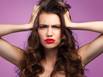 Junge Frau fässt sich verärgert in die Haare | © Getty Images/Cecilie_Arcurs