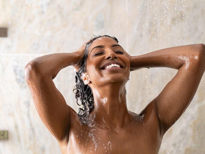 Frau unter der Dusche wäscht sich die Haare | © Getty Images/Ridofranz