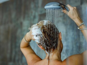 Frau wäscht sich die Haare mit Shampoo | © Getty Images/skynesher