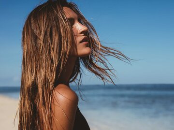 Dunkelblonde Frau blickt auf das Meer | © Getty Images/Jacob Ammentorp Lund