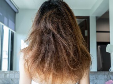 Rückansicht einer Frau mit unordentlichem und beschädigtem Haar | © Getty Images/Boy_Anupong