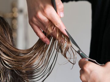 Hände schneiden mit einer Friseurschere lange Haare ab | © AdobeStock/up-foto