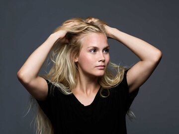 Blonde Frau mit offenen Haaren blickt genervt auf die Seite | © Getty Images/Solskin