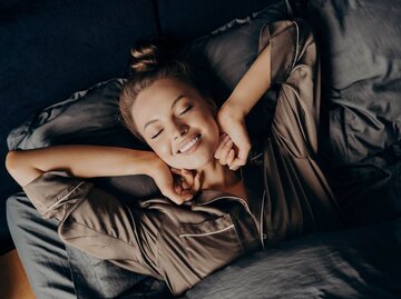 Person im Bett mit Haardutt | © Getty Images/Viorel Kurnosov