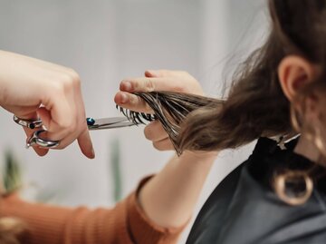 Person schneidet Haare | © Getty Images/SBenitez