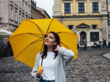 Person mit gelbem Regenschirm | © Getty Images/Anna Blazhuk