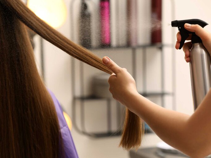 Beim Friseur wird Haarspray auf Haare gesprüht | © Adobe Stock/New Africa