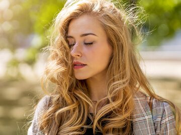 Frau mit langen, welligen Haaren im Wind | © Getty Images/PIKSEL