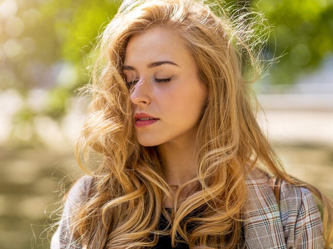 Frau mit langen, welligen Haaren im Wind | © Getty Images/PIKSEL