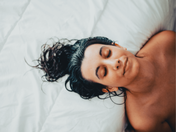 Frau mit nassen Haaren auf dem Bett | © Getty Images/Elena González Hontoria/EyeEm