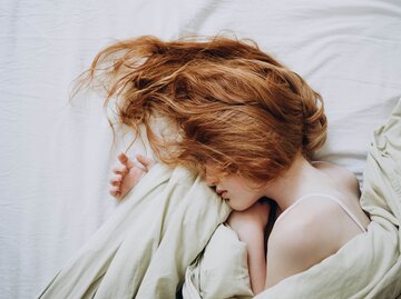 Frau mit roten Haaren schläft | © Getty Images/Evgeniia Rusinova