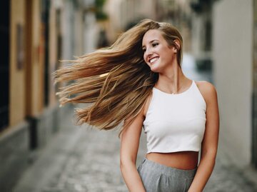 Frau mit langen blonden Haaren wirft ihre Mähne | © Getty Images/javi_indy