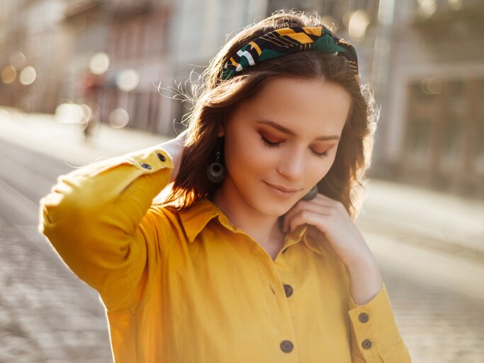 Schöne Frau mit gelbem Haarband im Herbst | © Getty Images/Ihor Khomych