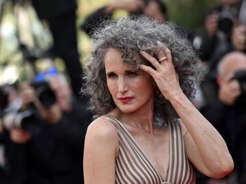 Andie MacDowell fasst sich in ihr graues Haar | © Getty Images/LOIC VENANCE