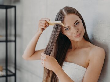 Frau kämmt sich ihre nassen Haare | © Getty Images/Viorel Kurnosov / EyeEm