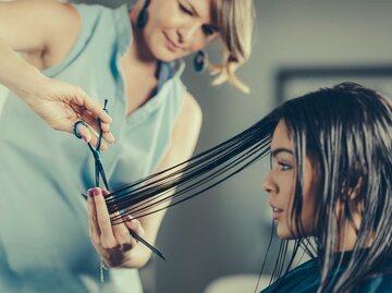 Frau sitzt beim Friseur und lässt sich ihre Haare schneiden.  | © Getty Images / Stevica Mrdja / EyeEm