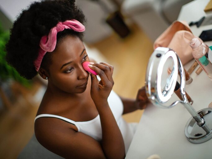 Person schminkt sich mit Make-up-Schwämmchen | © Getty Images/Aja Koska