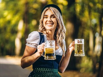 Person im Dirndl und mit Maßkrügen | © Getty Images/bedya