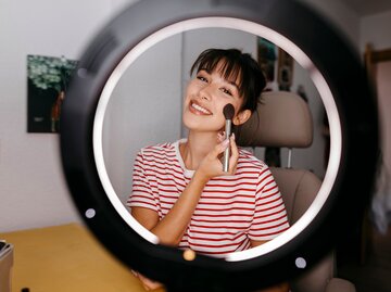 Fröhliche junge Frau beim Schminken | © gettyimages.de | Westend61