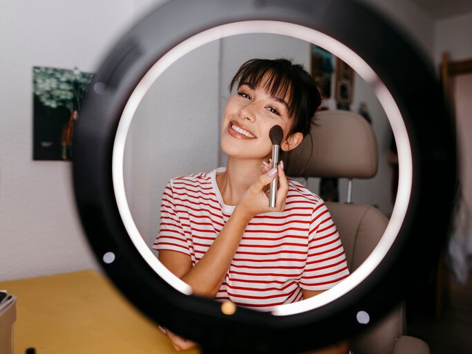 Fröhliche junge Frau beim Schminken | © gettyimages.de | Westend61