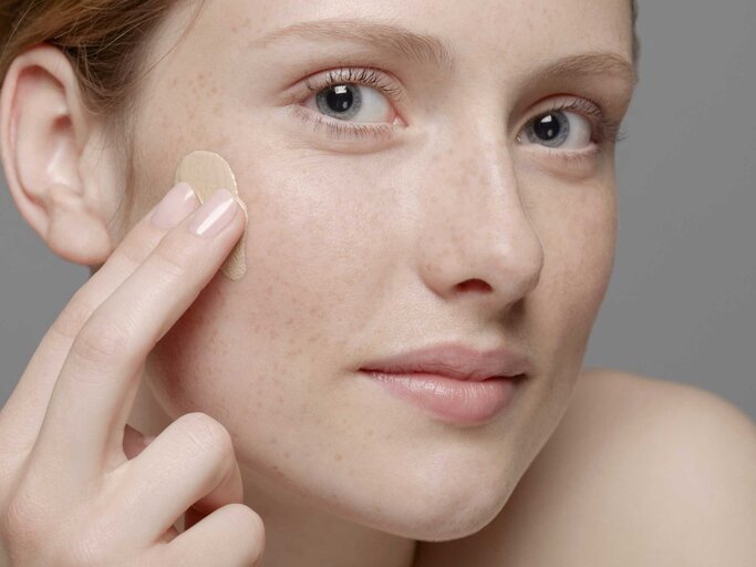 Frau trägt Make-up auf dem Gesicht auf | © Getty Images/Emma Kim