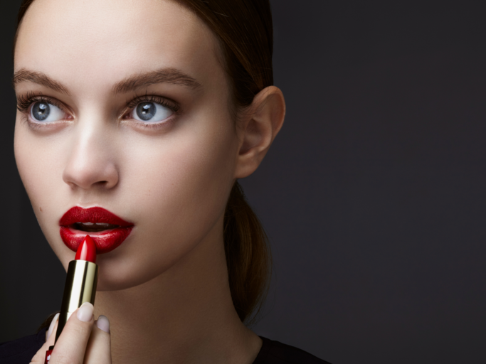 Frau trägt roten Lippenstift auf | © Getty Images/Ada Summer