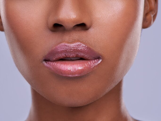 Frau mit vollen und schimmernden Lippen | © Getty Images/PeopleImages