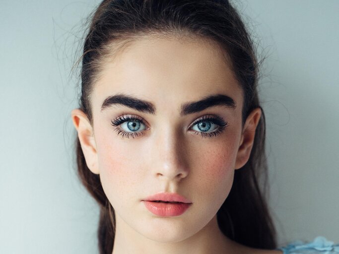 Junge, schöne Frau mit blauen Augen | © Getty Images/CoffeeAndMilk