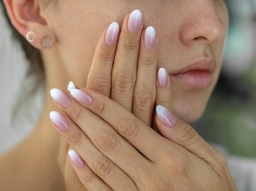 Nahaufnahme von Händen mit Ombré-Maniküre | © Getty Images/Sergii Petruk