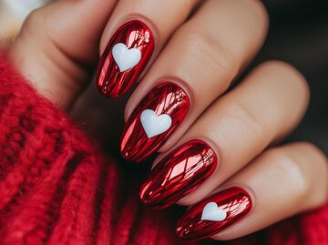 Rote Metallic-Nägel mit Herzen | © Adobe Stock/ALL YOU NEED studio/ KI-generiert