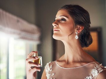 Braut sprüht sich Parfum auf. | © Getty Images/Hiraman
