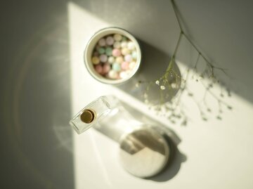 Parfum steht zusammen mit Puder-Kugeln im Licht | © Getty Images/Kristina Strasunske
