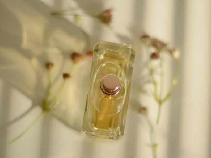 Stehender Parfum Flacon umringt von Blumen | © Getty Images/Kristina Strasunske