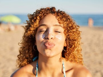 Person mit Sonnencreme im Gesicht | © Getty Images/Javier Sanz