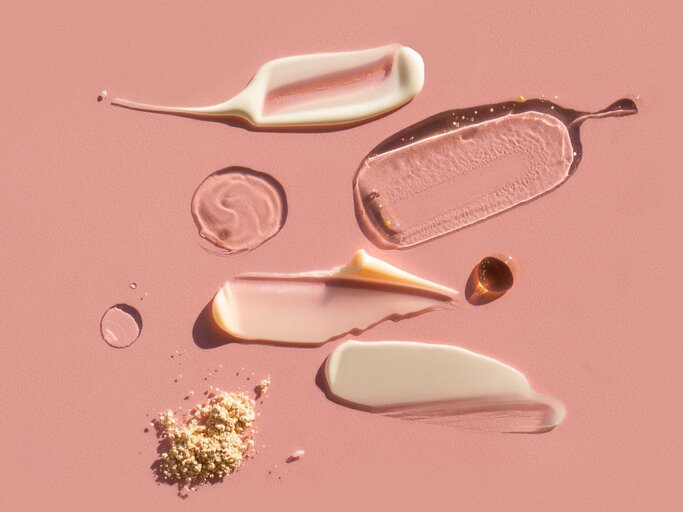 Mehrere Hautpflegeprodukte auf pinkem Untergrund | © Getty Images/Anna Efetova