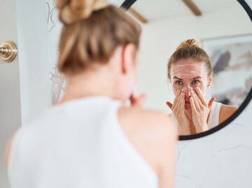 Eine Frau wäscht ihr Gesicht mittels Double Cleansing | © GettyImages/Sergey Mironov