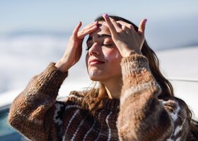 Frau trägt sich Feuchtigkeitscreme im Winter auf