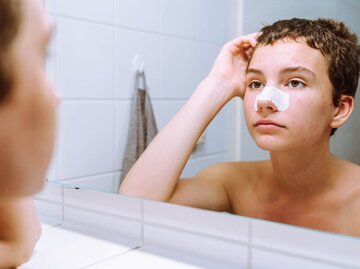 Frau mit Nasenpatch im Spiegel | © Getty Images/Larisa Stefanuyk