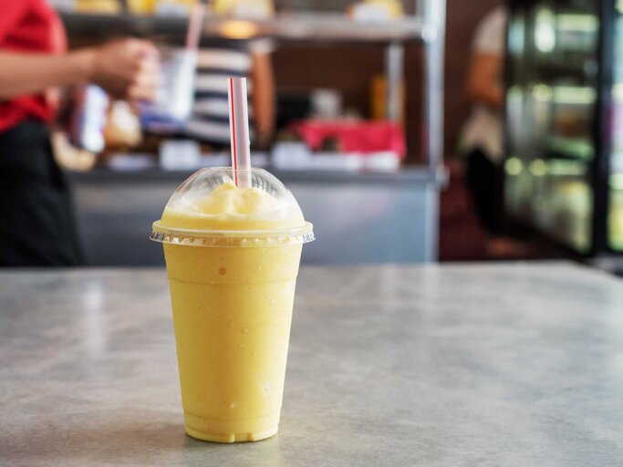 Gelber Smoothie in einem To-Go Becher | © Getty Images/Nora Carol Photography