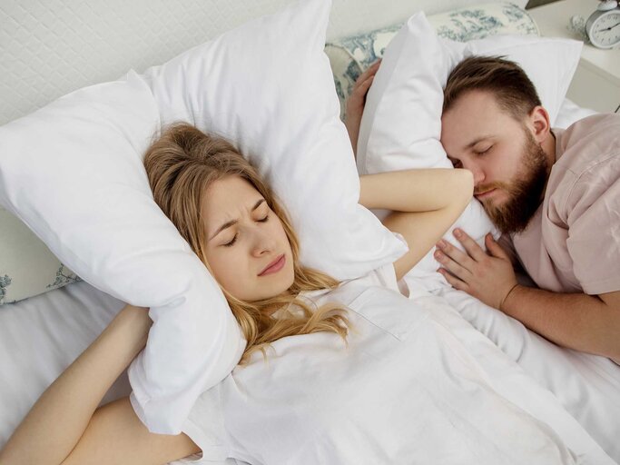 Paar liegt im Bett, doch die Frau kann nicht schlafen, weil der Mann so laut schnarcht. | © Getty Images / Agnieszka Marcinska - EyeEm