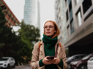 Rothaarige Frau vor Wolkenkratzer | © Getty Images/Halfpoint Images