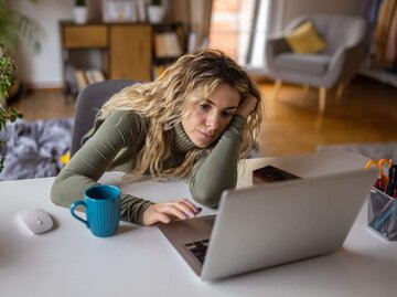 Person sitzt müde vor Laptop | © Getty Images/miodrag ignjatovic