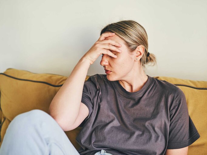 Frau fasst sich wegen Kopfschmerzen an die Stirn | © Getty Images/Ekaterina Goncharova