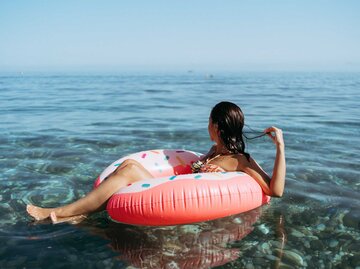 Frau sitzt auf einem Schwimmring im Meer | © Getty Images/Ana Rocio Garcia Franco